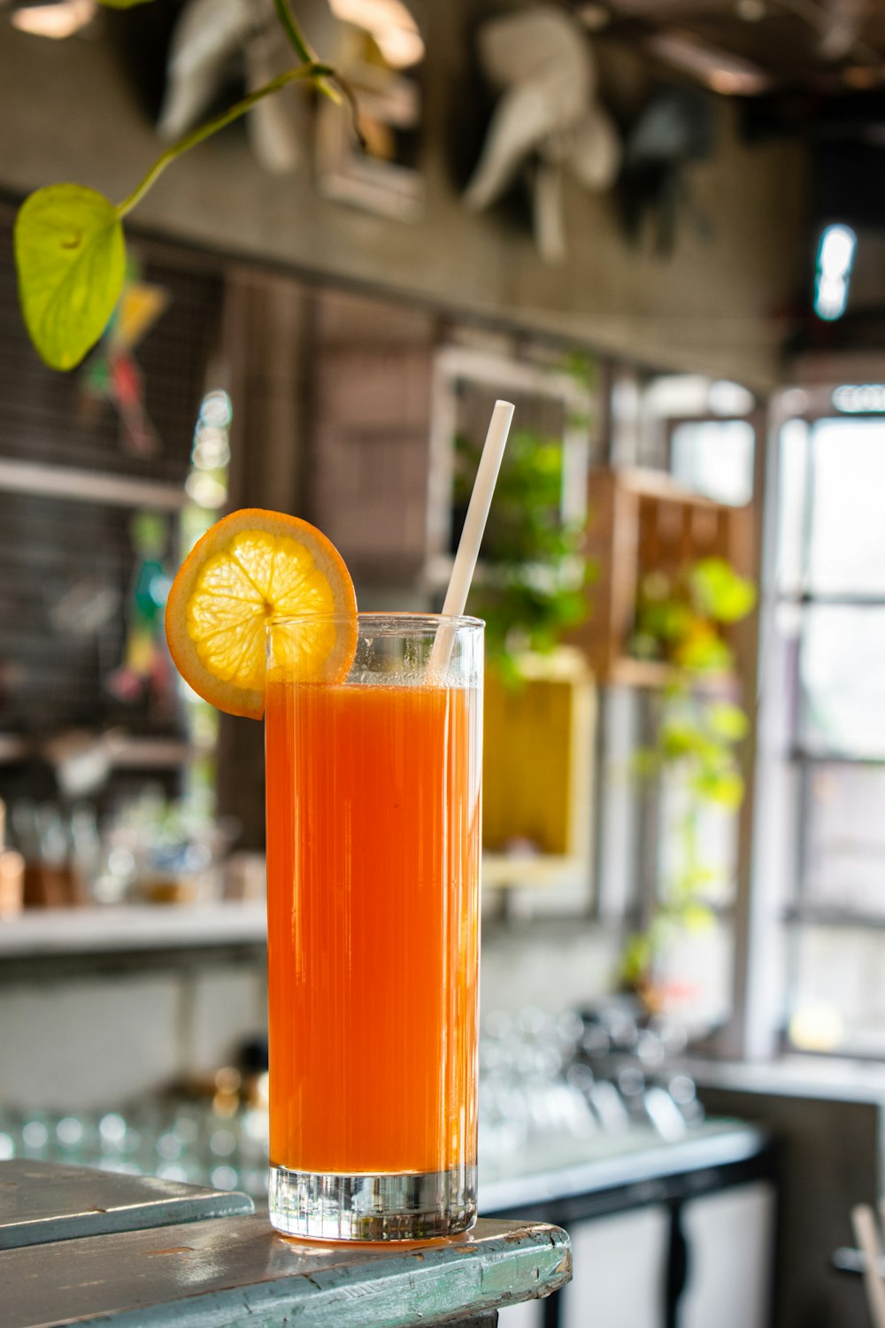 orange juice in clear drinking glass with sliced lemon