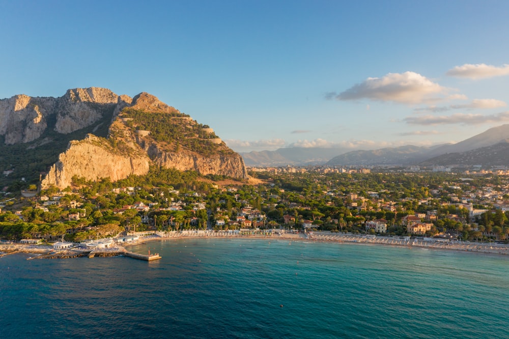 barca bianca sul mare vicino alla montagna durante il giorno