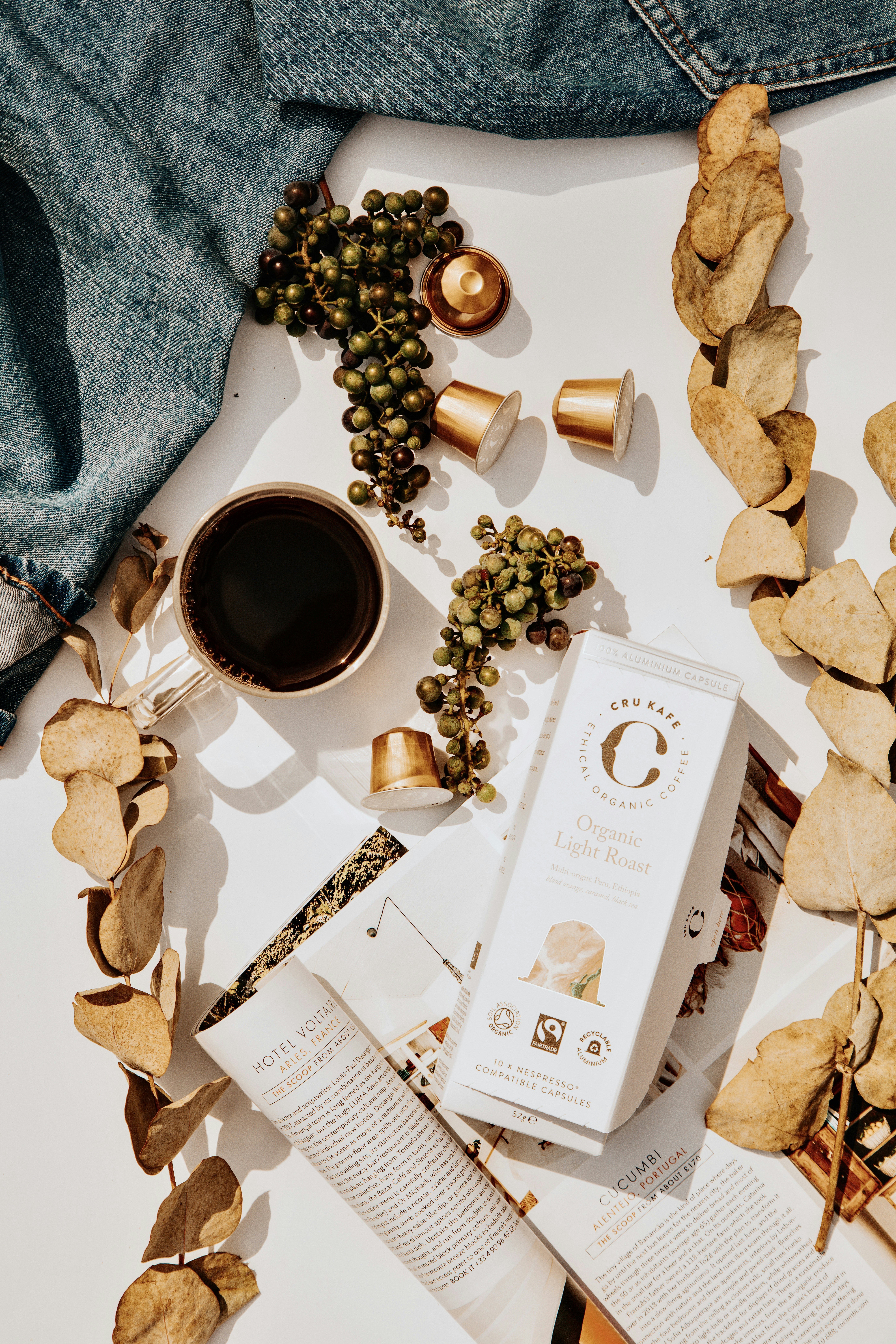 white and gold iphone box beside brown coffee beans and white ceramic mug