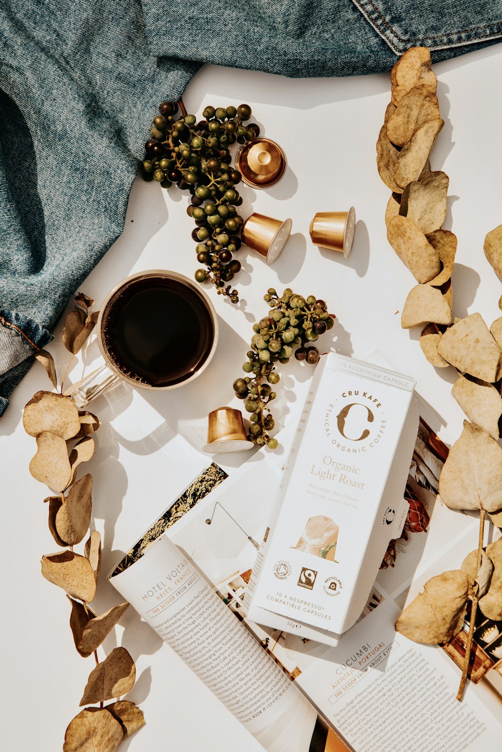 white and gold iphone box beside brown coffee beans and white ceramic mug