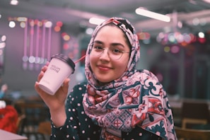 A cheerful mom sipping coffee while shopping with her kids.