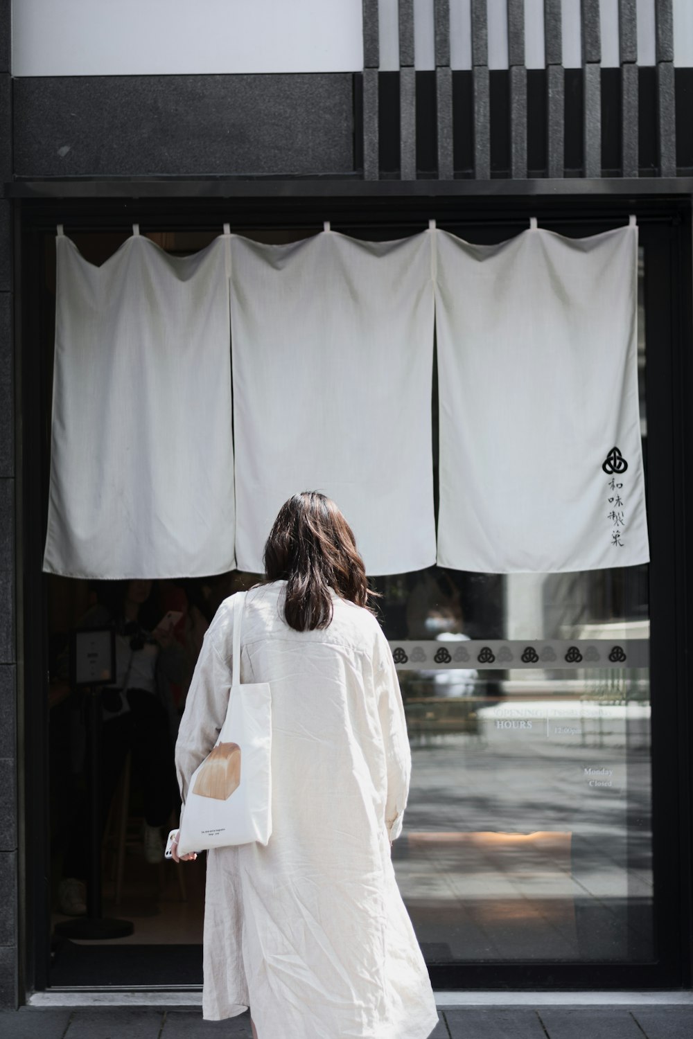 woman in white long sleeve shirt standing in front of white curtain