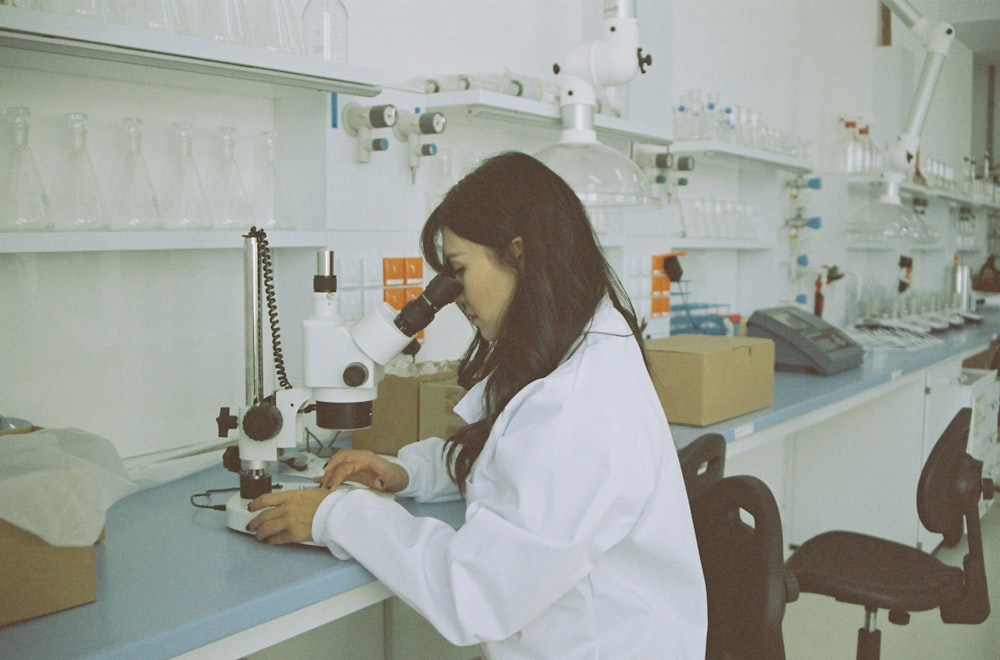 woman in white long sleeve shirt using white and black sewing machine