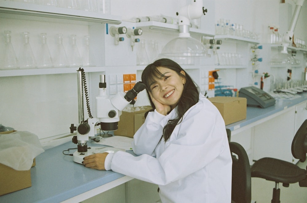 woman in white laboratory gown holding black microphone
