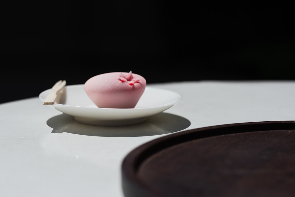 pink candle on white ceramic saucer