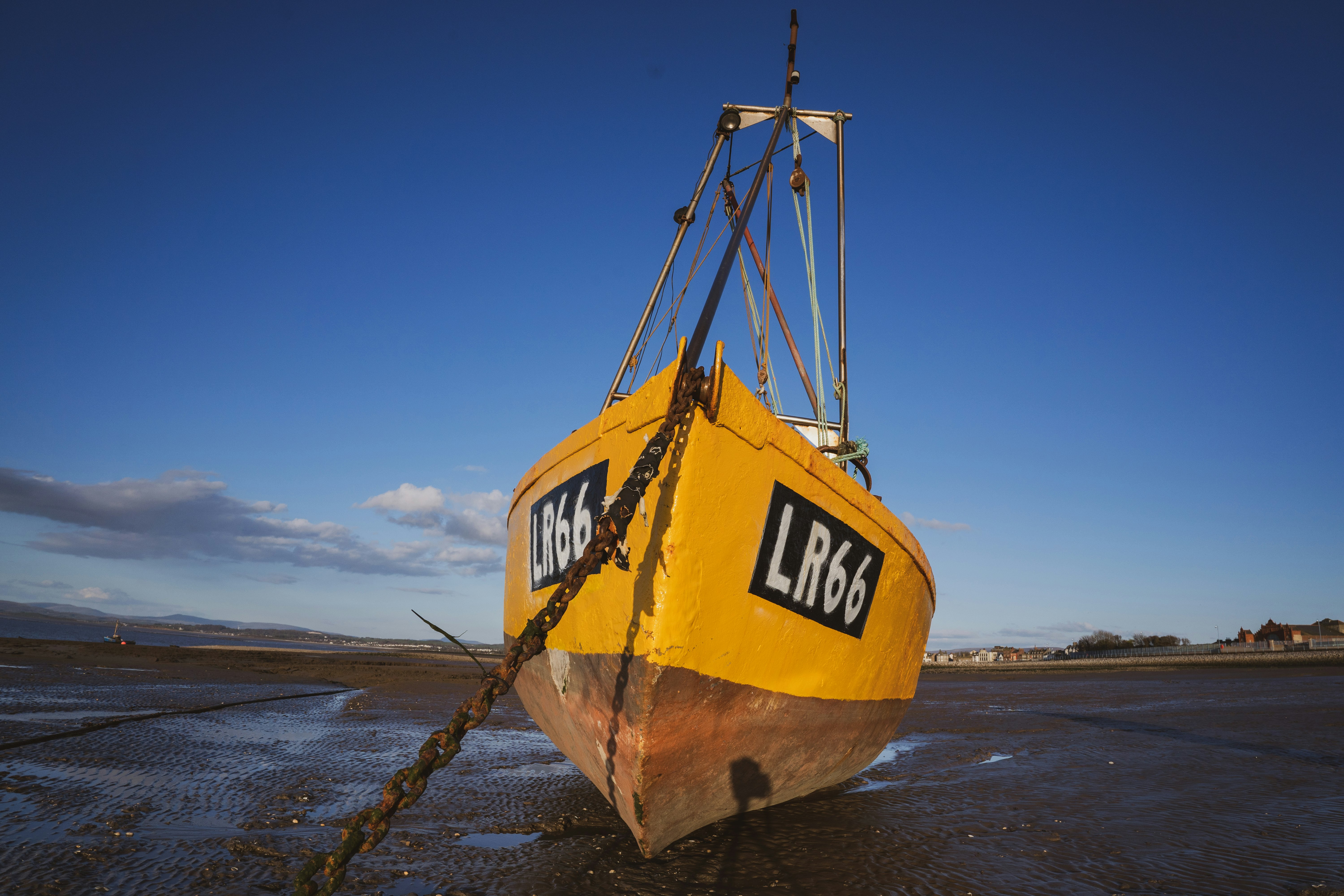 yellow and black boat on brown sand during daytime