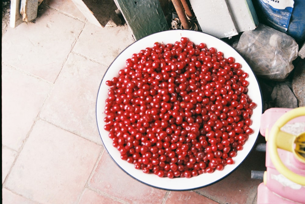 red round fruits on white round ceramic bowl