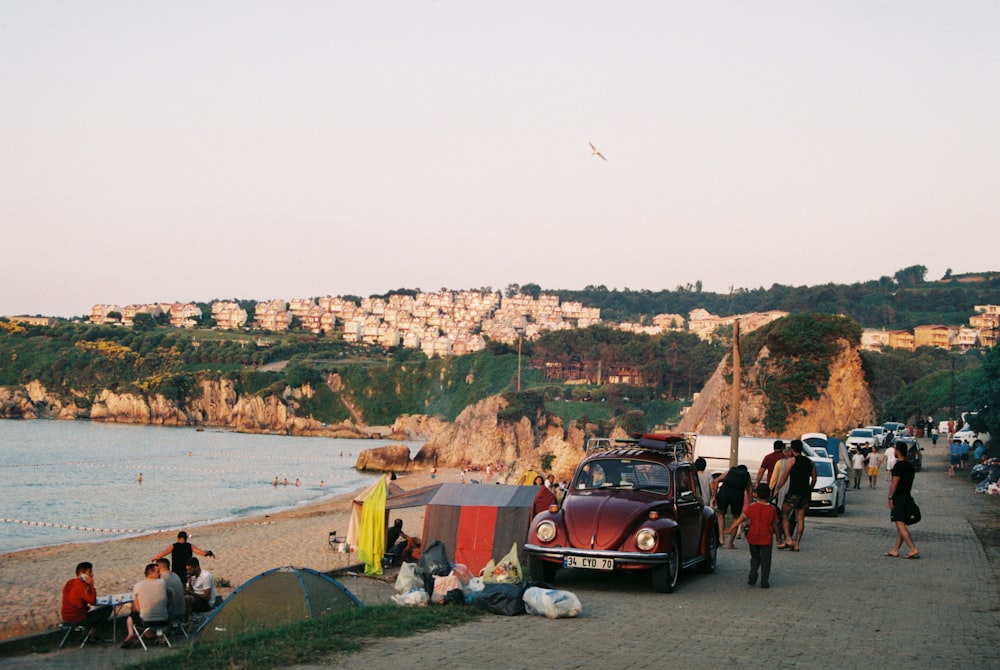 people standing near red car during daytime