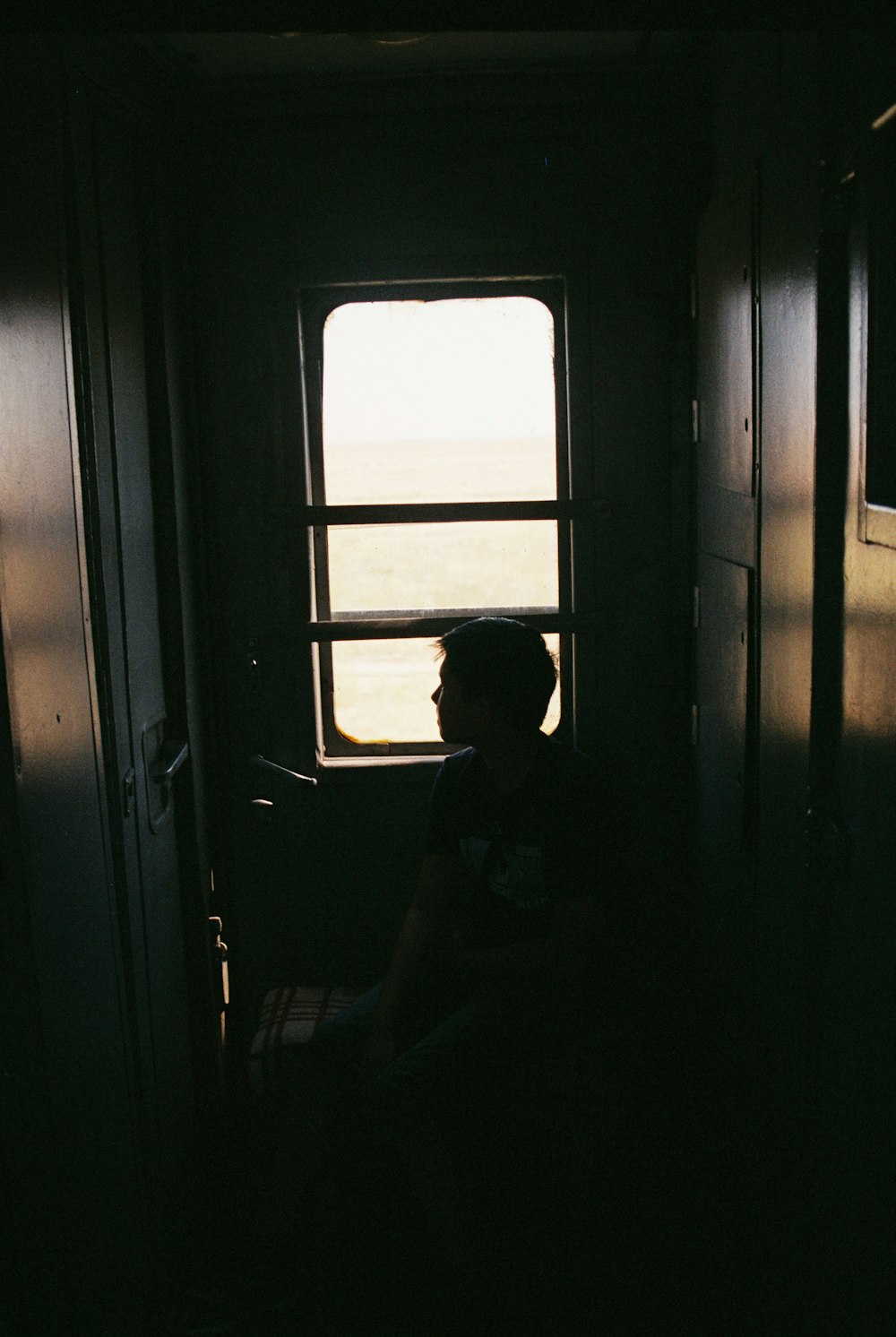 man in black shirt sitting on chair near window during daytime