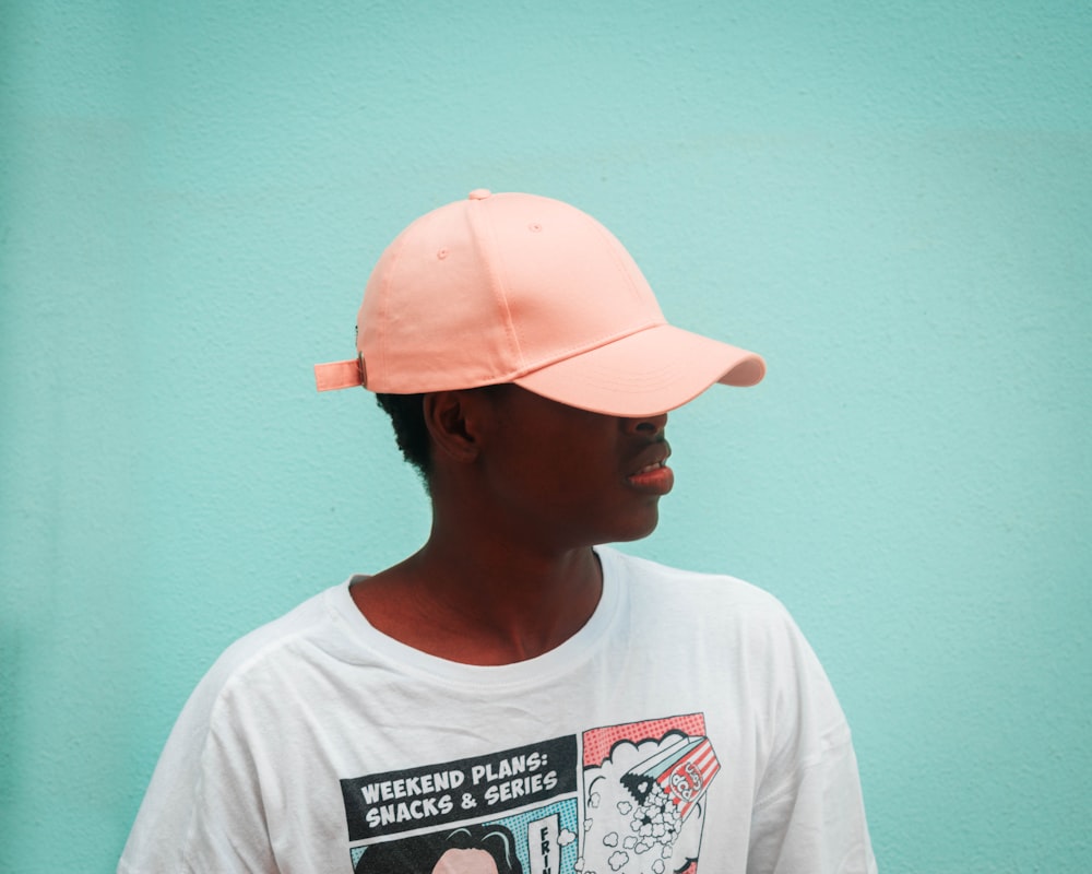 man in white crew neck t-shirt wearing orange cap