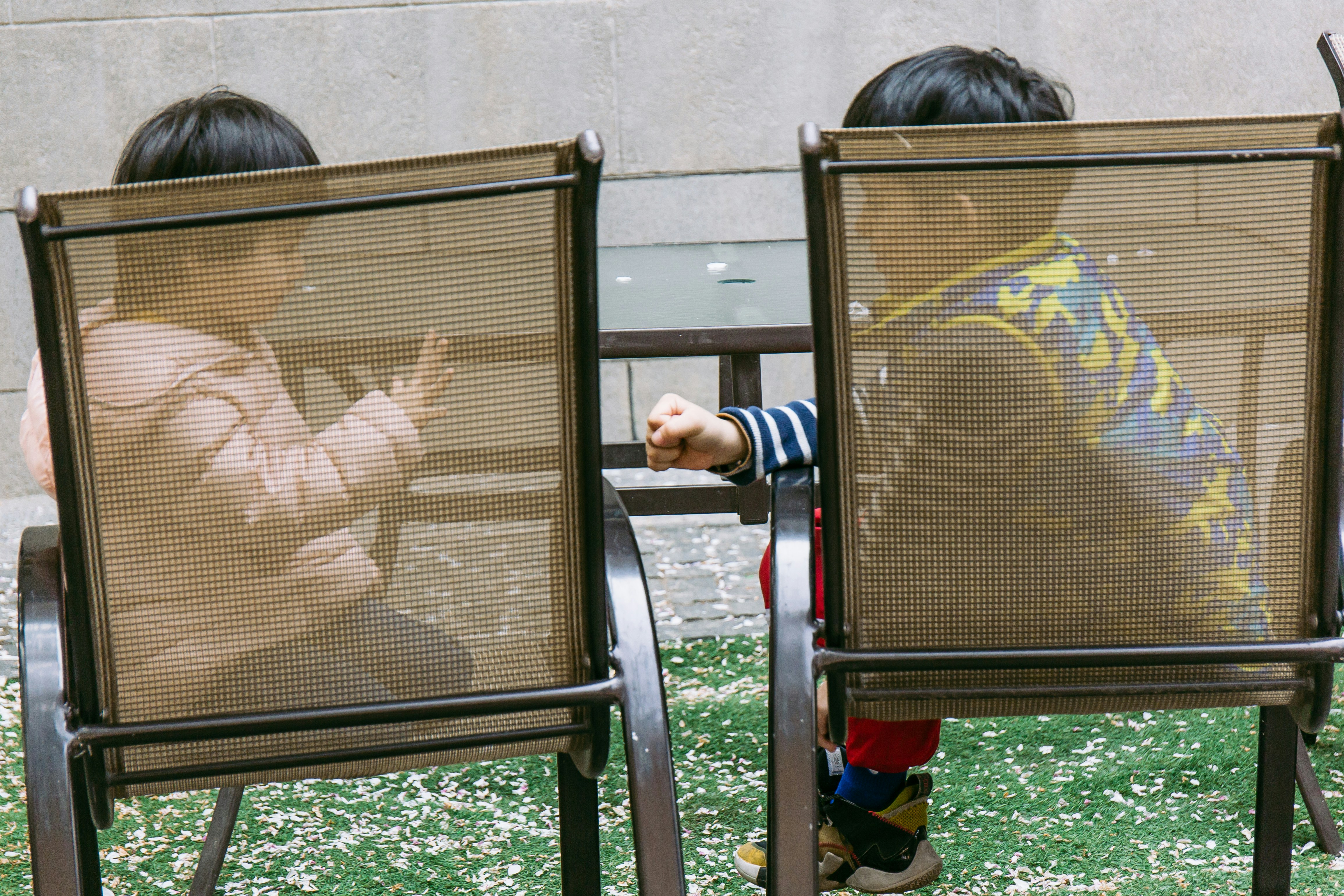 boy in brown shirt sitting on black metal bench