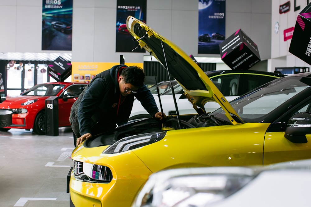 man in black jacket and black pants riding yellow car