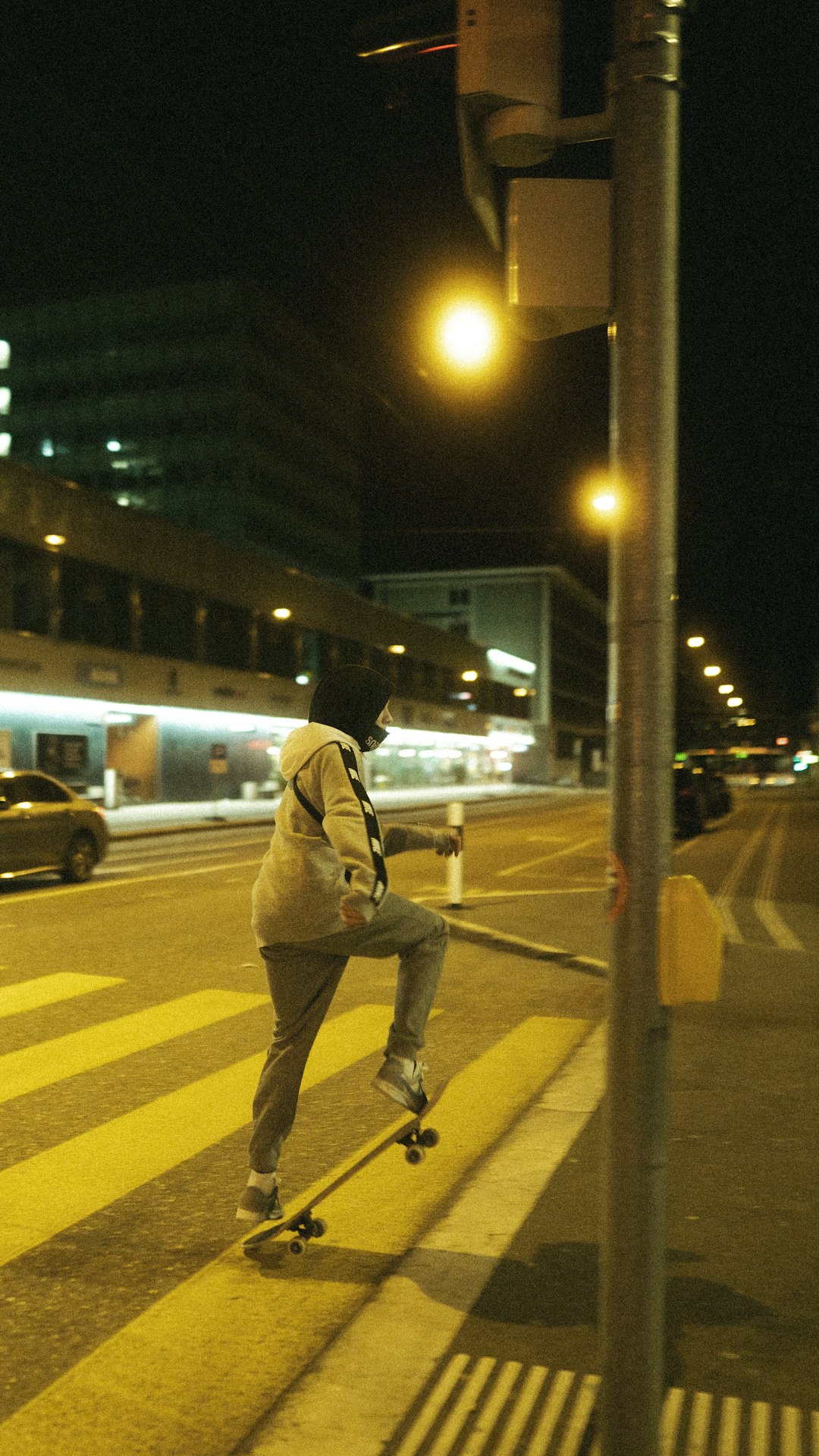 man in brown jacket and pants standing on sidewalk during night time