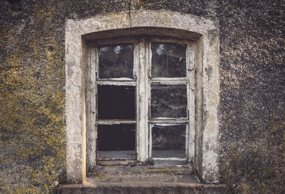 weißes Holzfenster an gelber und brauner Wand