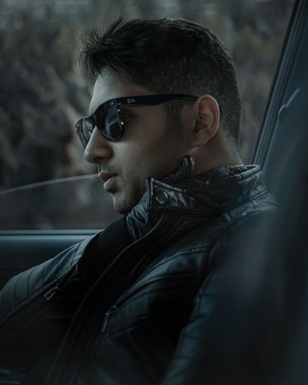 man in black leather jacket wearing black sunglasses