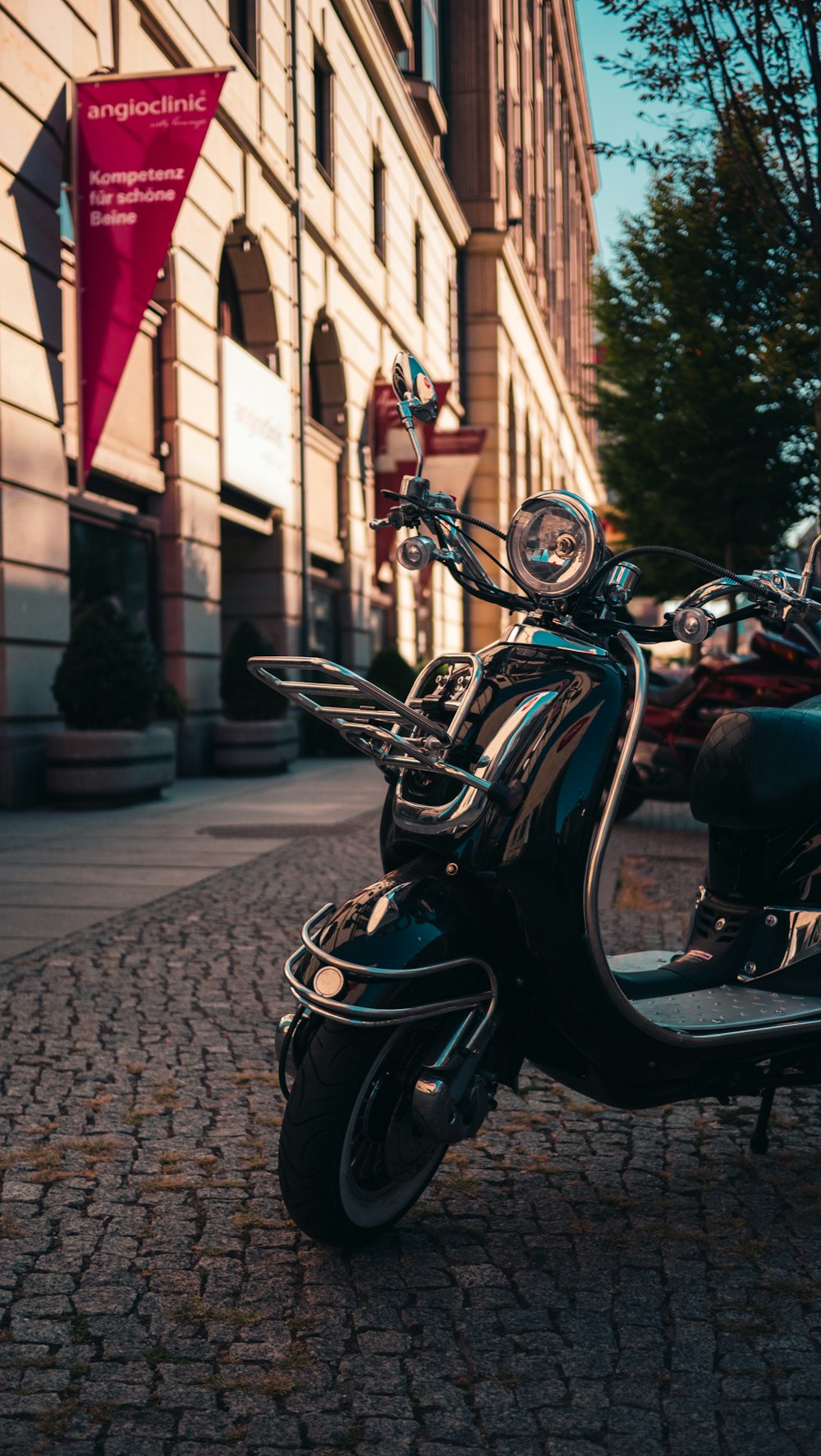 black and red motorcycle parked on sidewalk during daytime