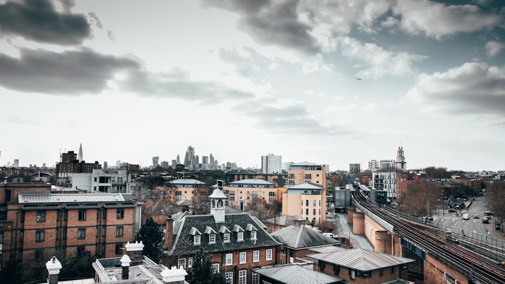 brown and white concrete buildings under white clouds during daytime