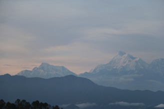A tranquil view of the snow-capped Himalayan peaks glowing softly at dawn.