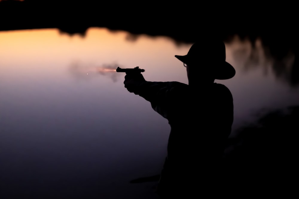 silhouette of man holding gun