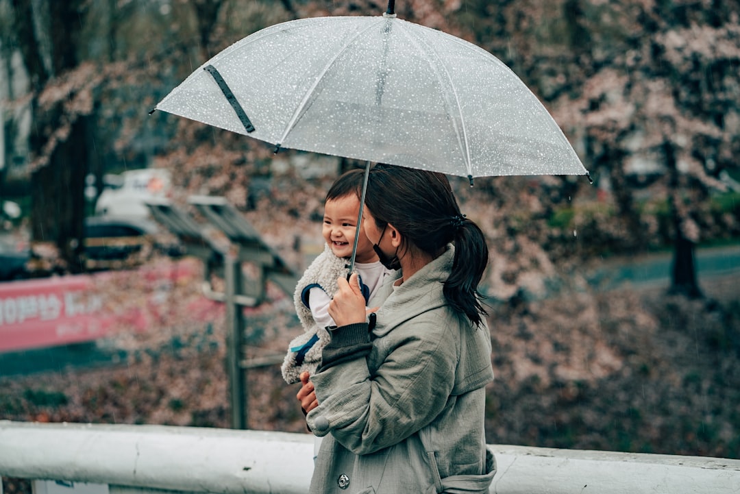 woman in green coat holding umbrella