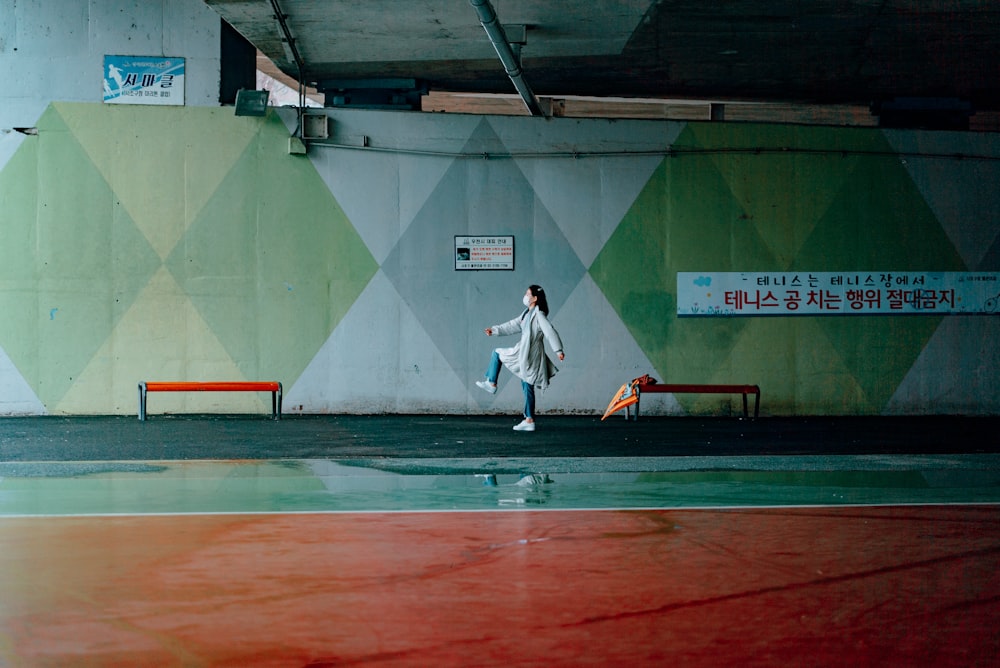 man in white long sleeve shirt and black pants walking on track field