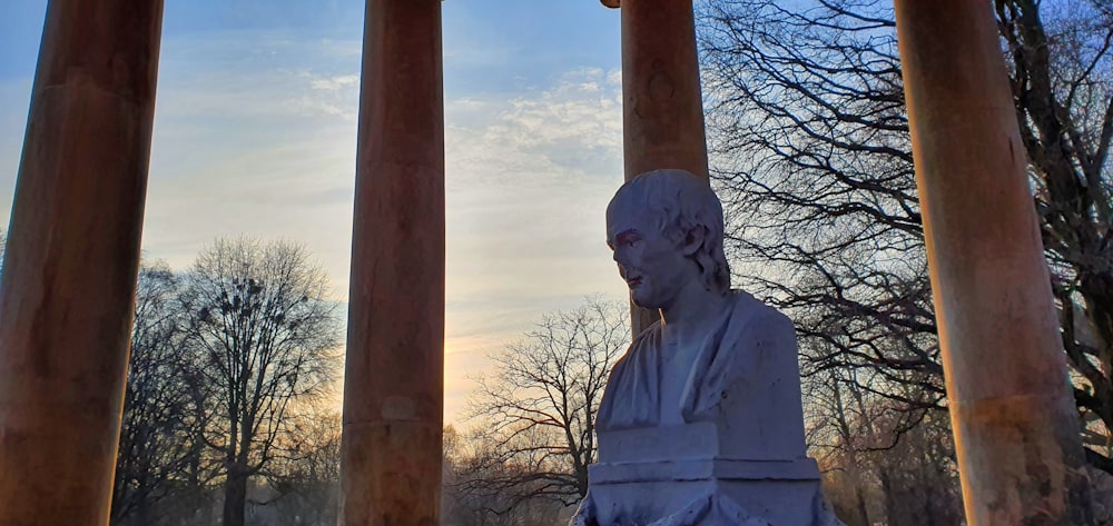 white concrete statue under white clouds during daytime