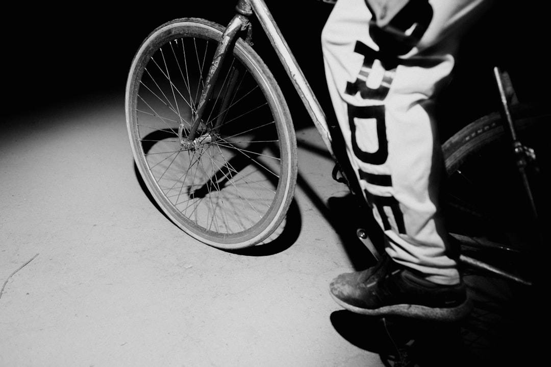 man in black and white jacket and pants riding bicycle