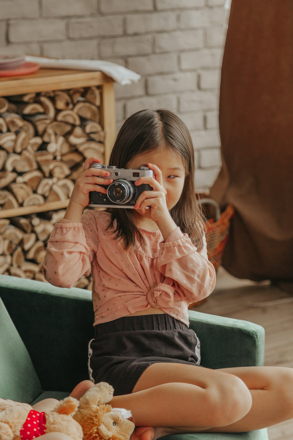 woman in pink long sleeve shirt and black pants holding camera