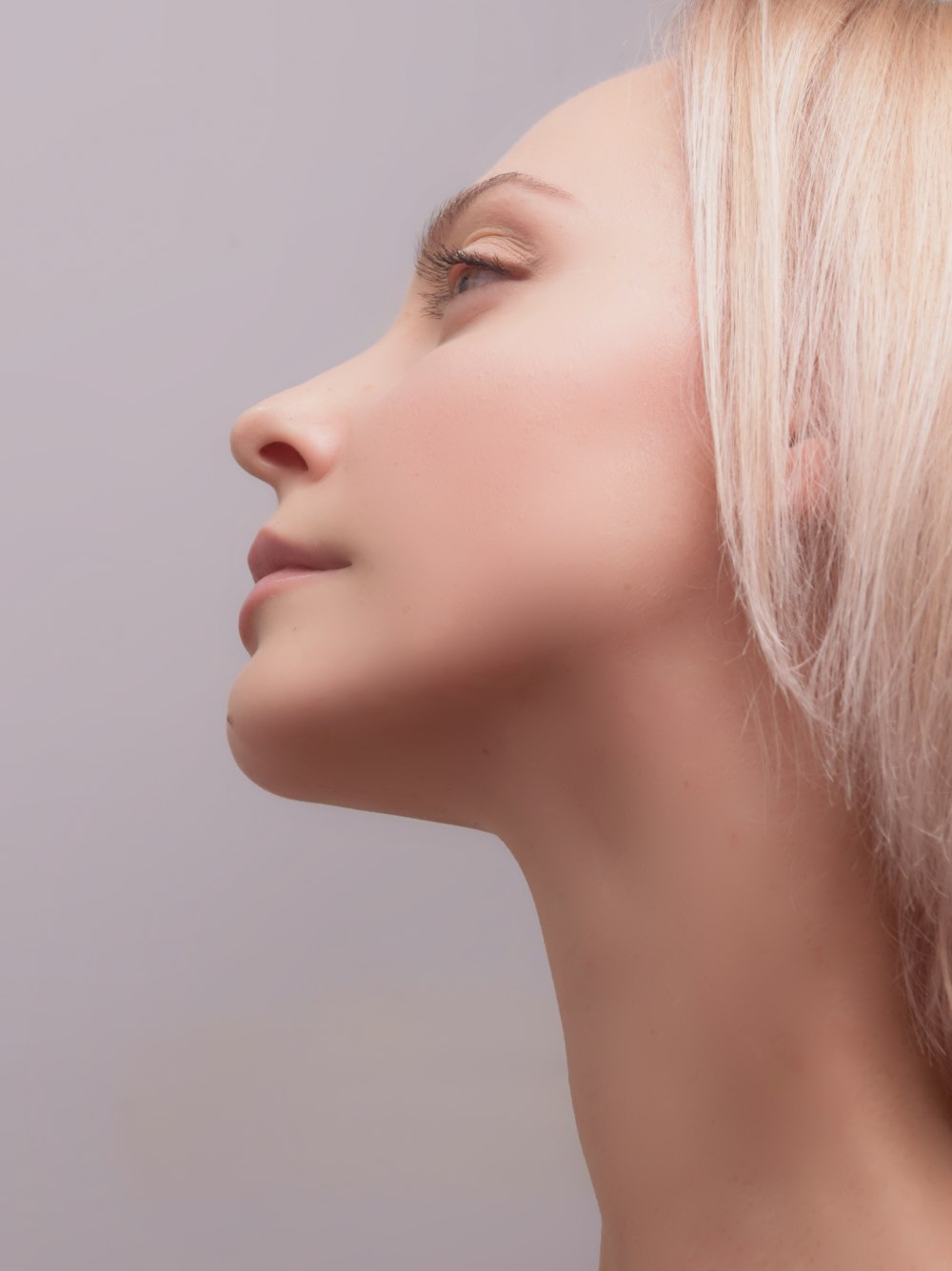 femme aux cheveux roses et au mur blanc