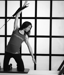 woman in white tank top and black leggings doing yoga