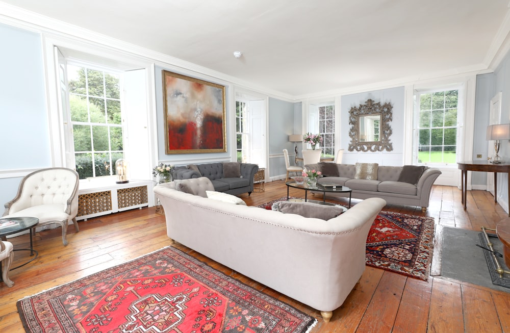 white and gray sofa chair on red and white floral area rug