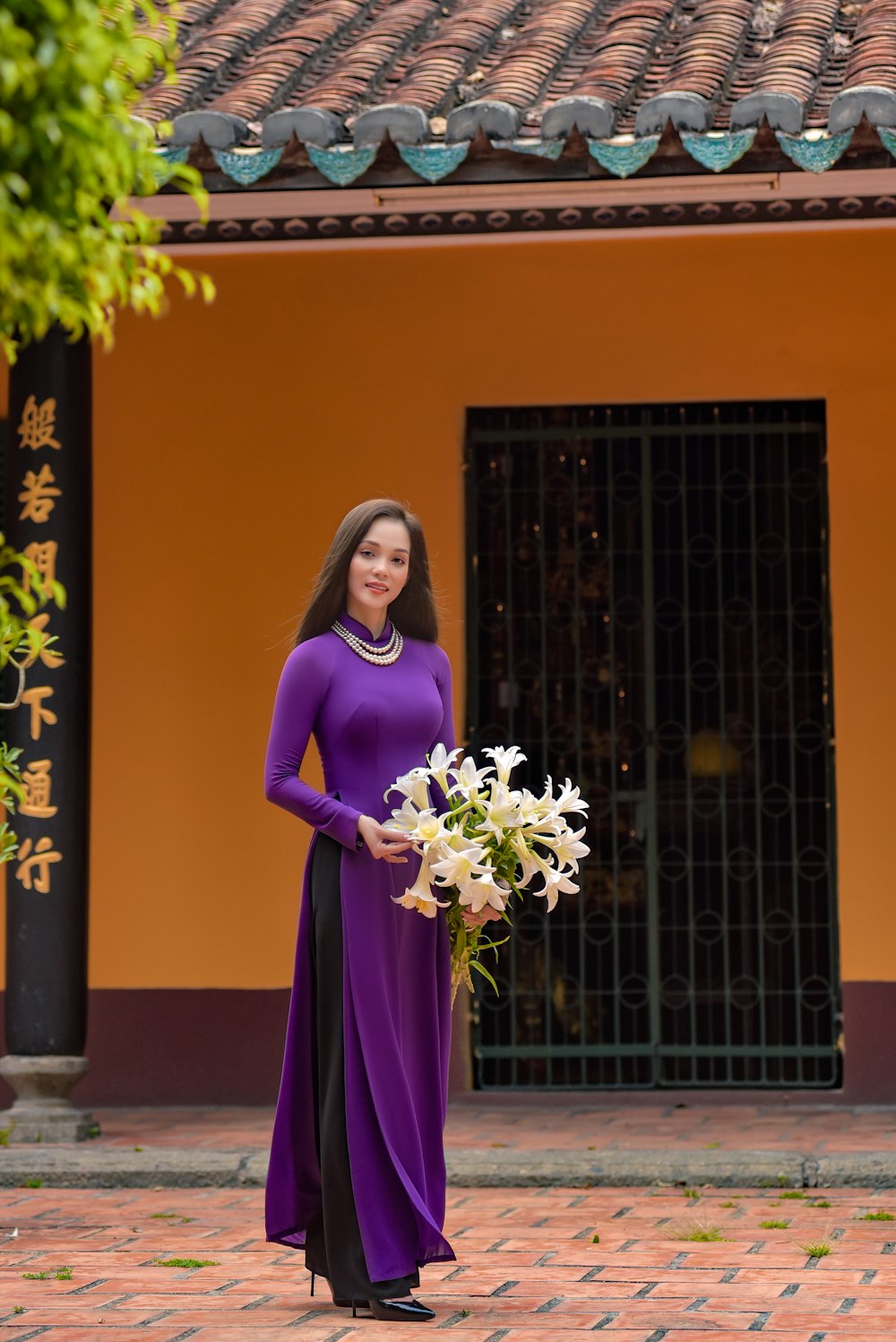 woman in purple long sleeve dress holding bouquet of flowers