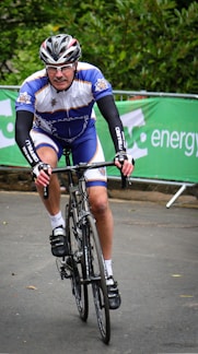 A cyclist racing on a scenic road during a championship event.