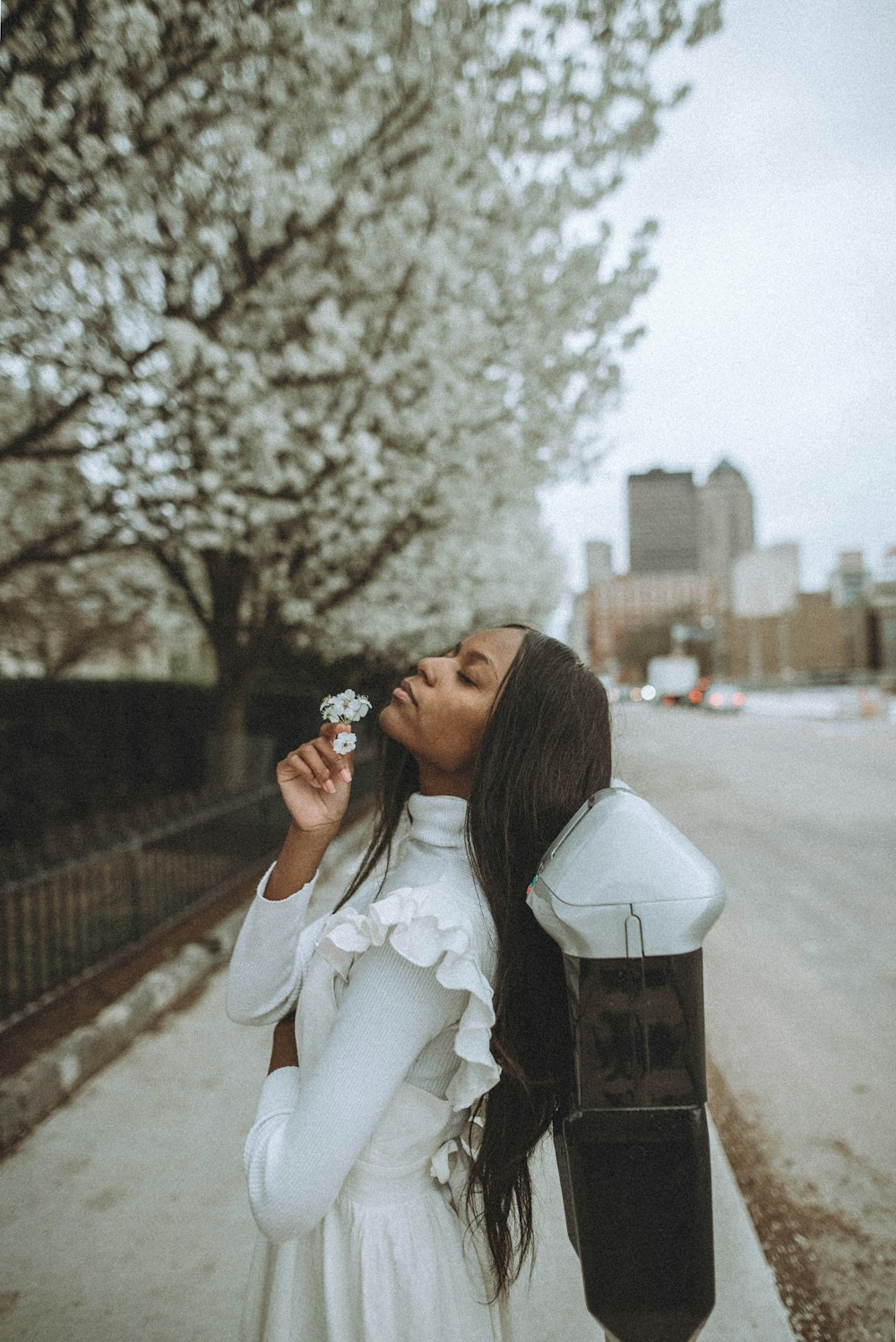 woman in white long sleeve shirt holding black camera