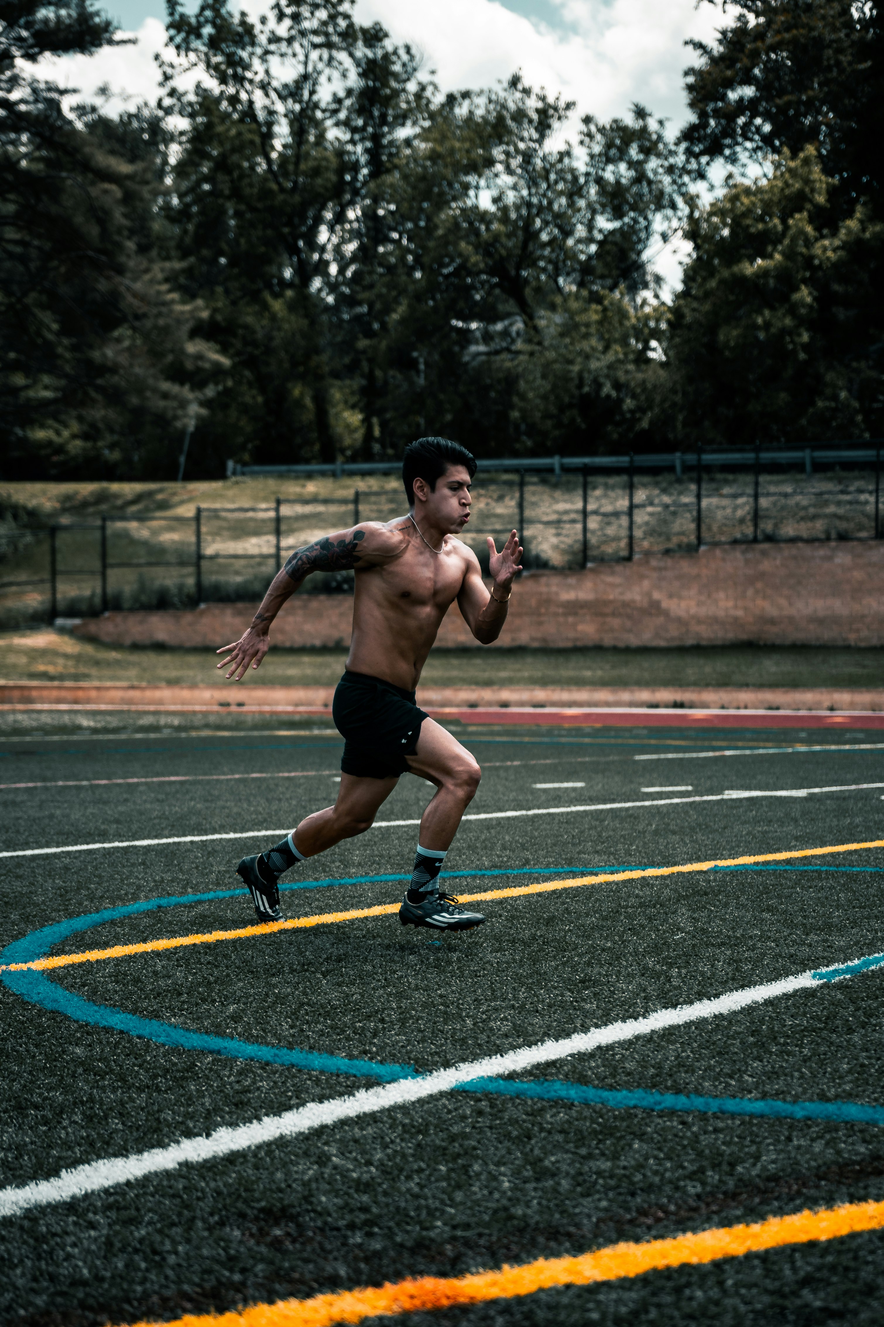 man in black shorts running on track field during daytime