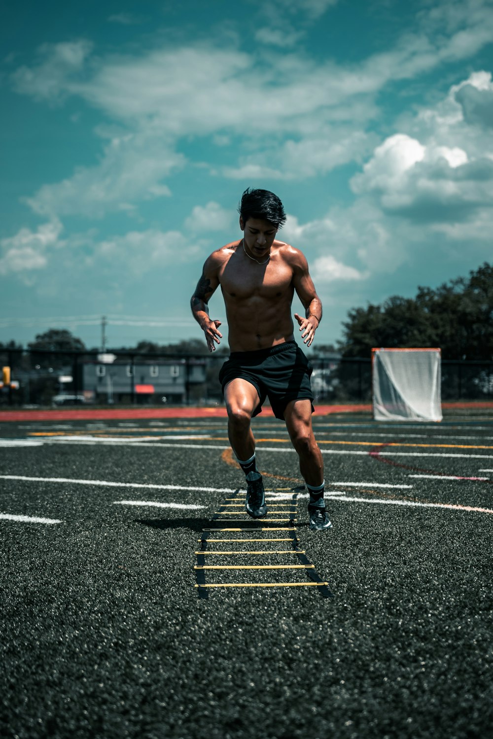 man in black shorts running on track field during daytime