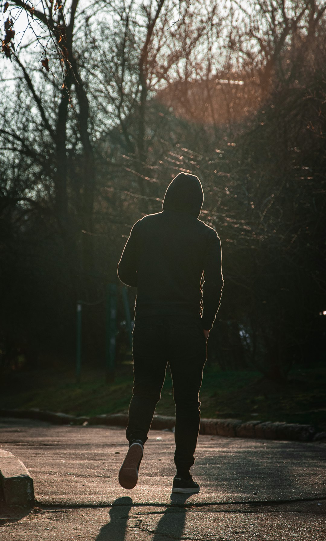 man in black hoodie standing on forest during daytime