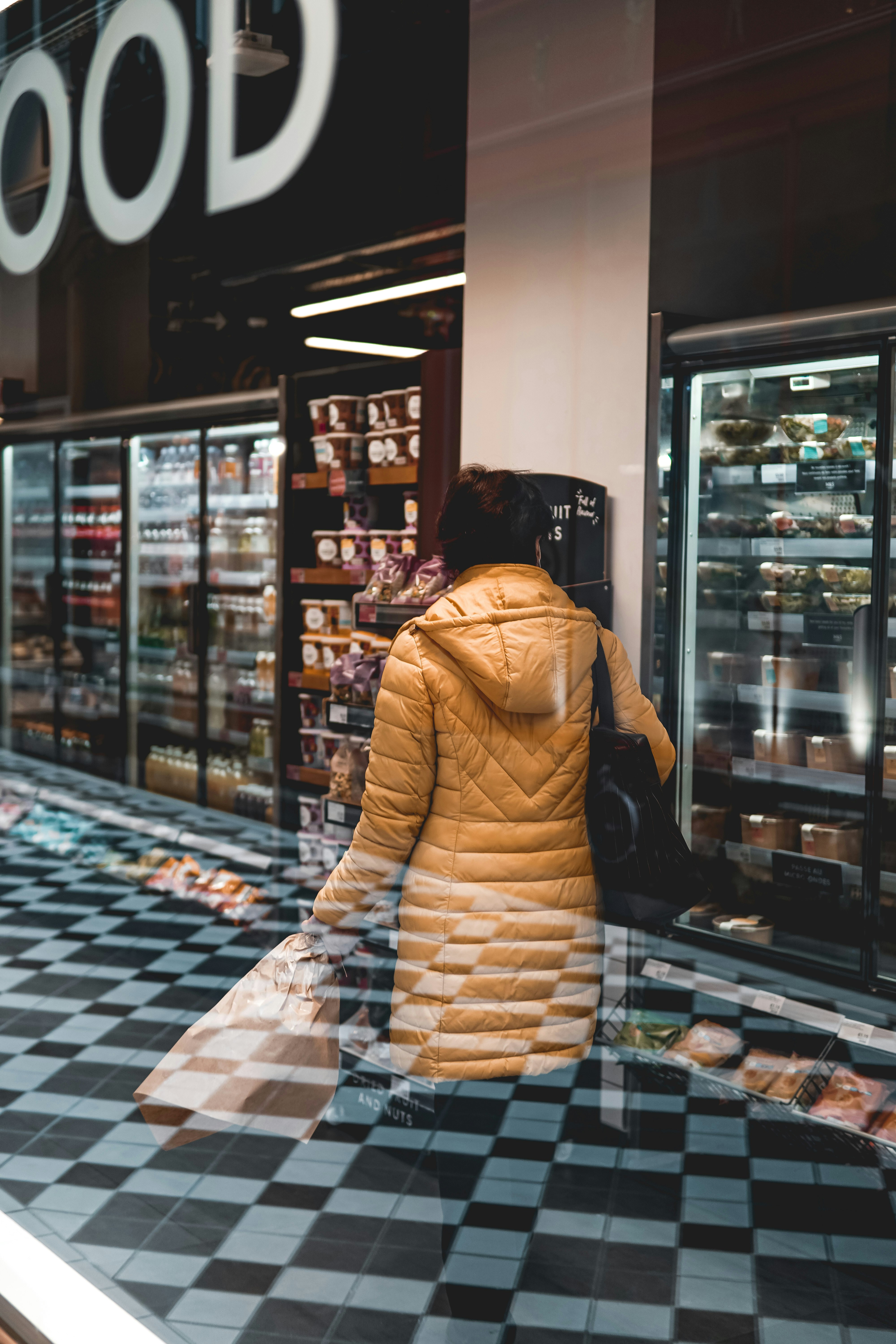 woman in brown and white dress standing near glass wall
