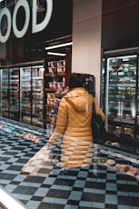 woman in brown and white dress standing near glass wall