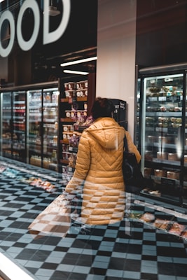 woman in brown and white dress standing near glass wall