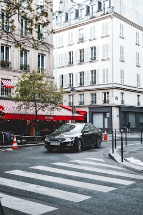 A learner driver taking a practical driving test in a European city setting.
