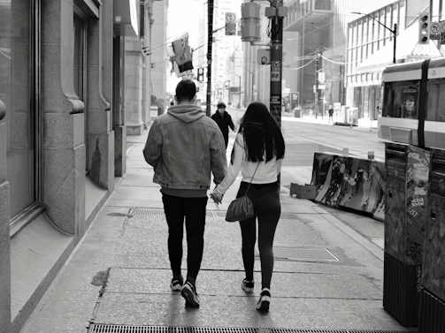 A candid moment of a celebrity couple walking hand in hand in the city.