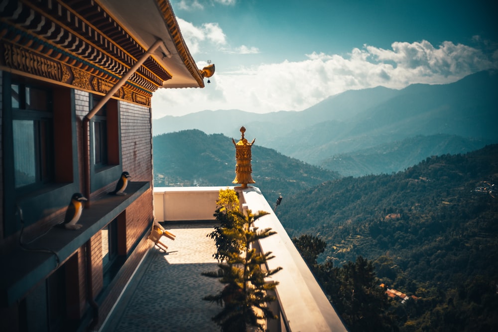 white and brown concrete building near green trees and mountains during daytime