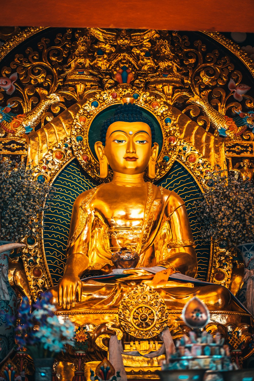 Statua di Buddha d'oro su parete floreale d'oro e blu