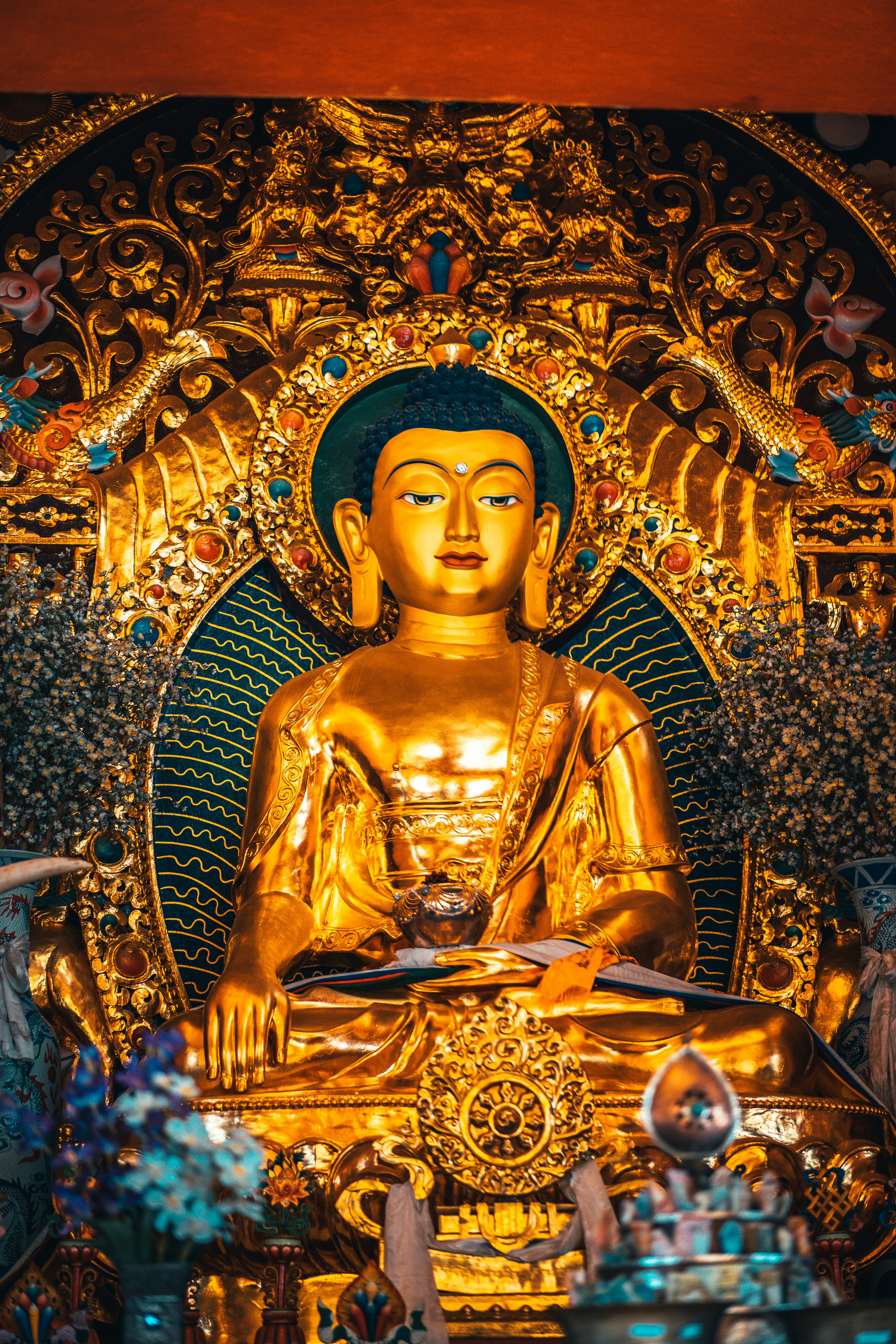 gold buddha statue on gold and blue floral wall