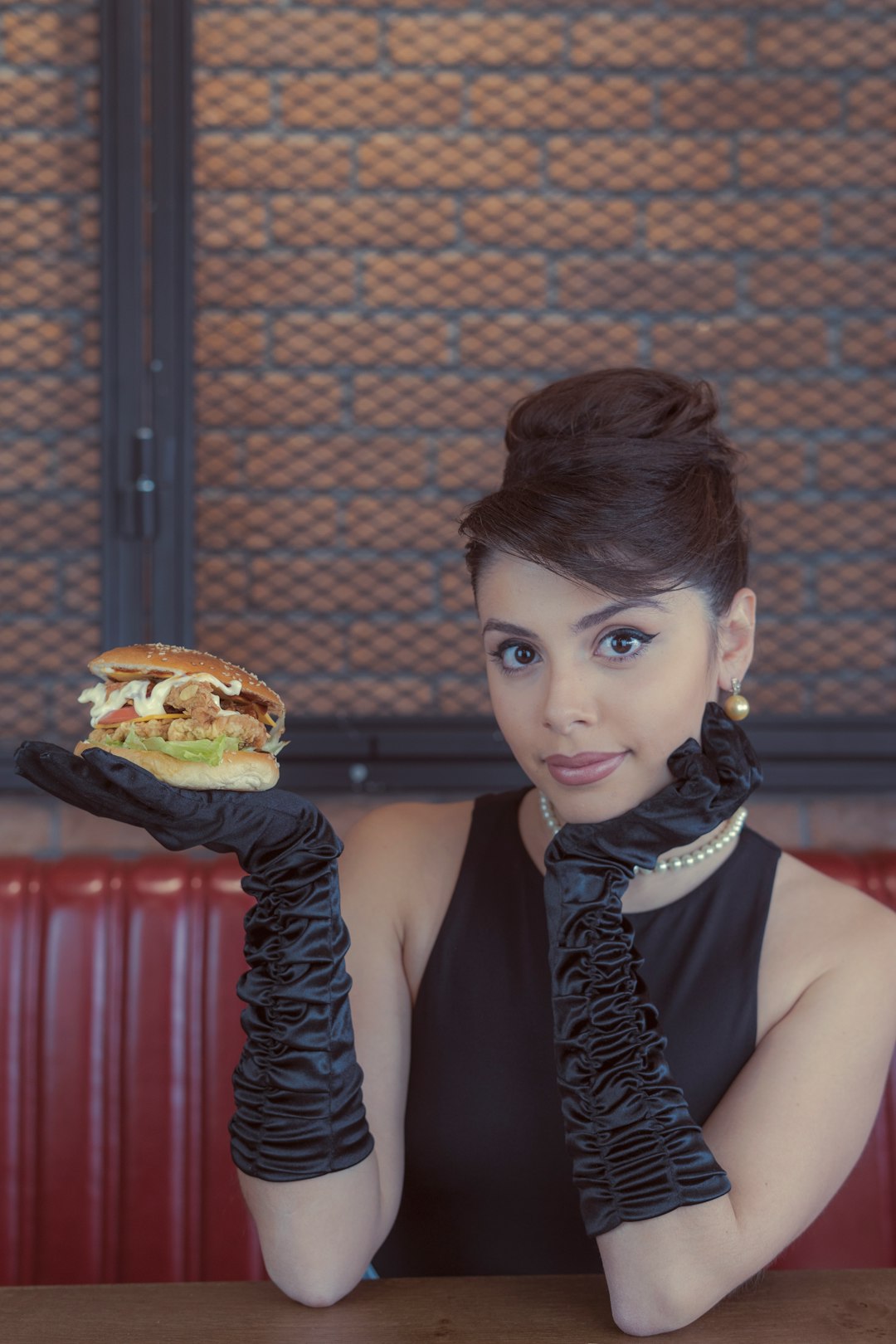 woman in black sleeveless top holding burger