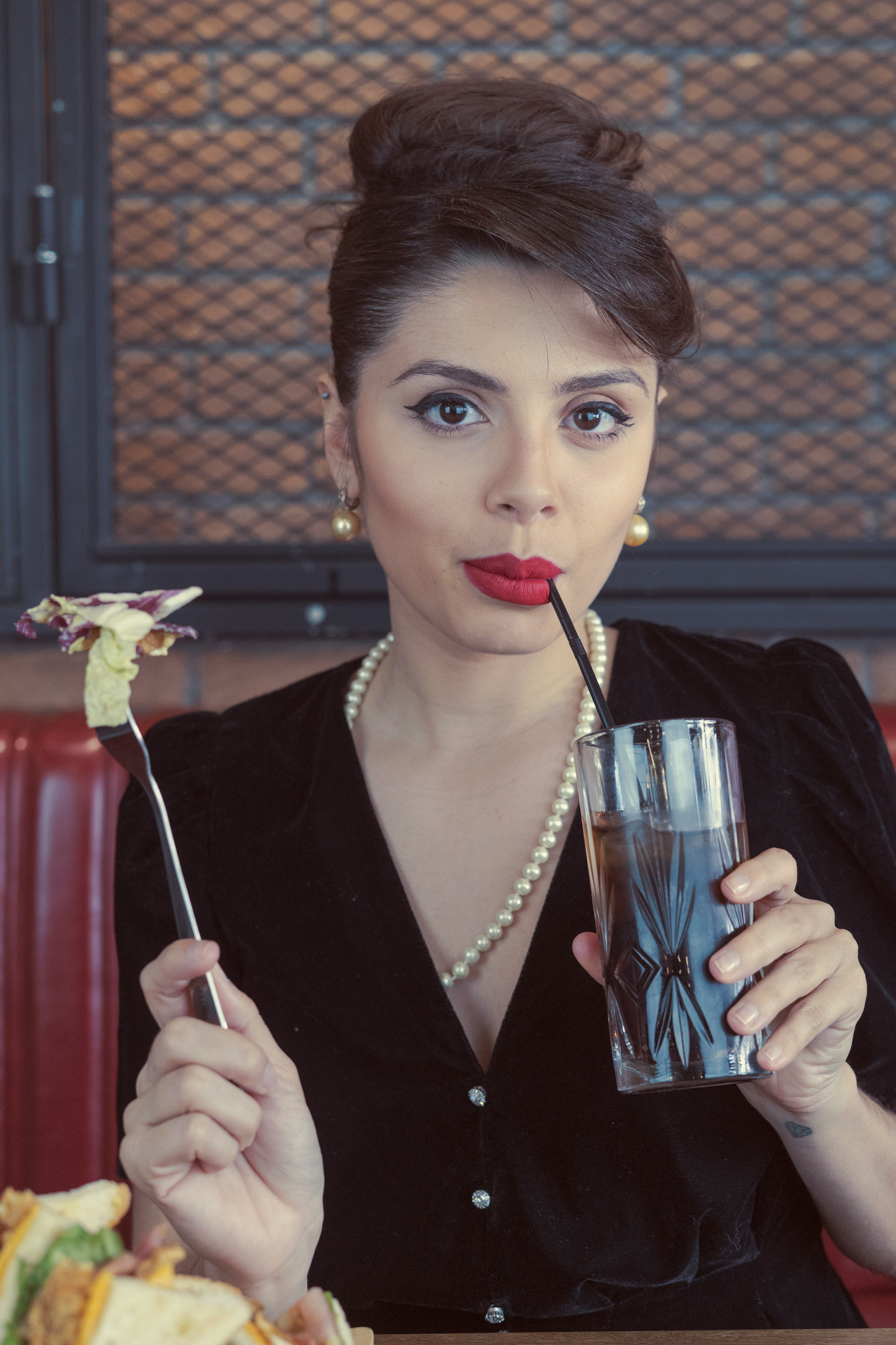 woman in black blazer holding clear drinking glass