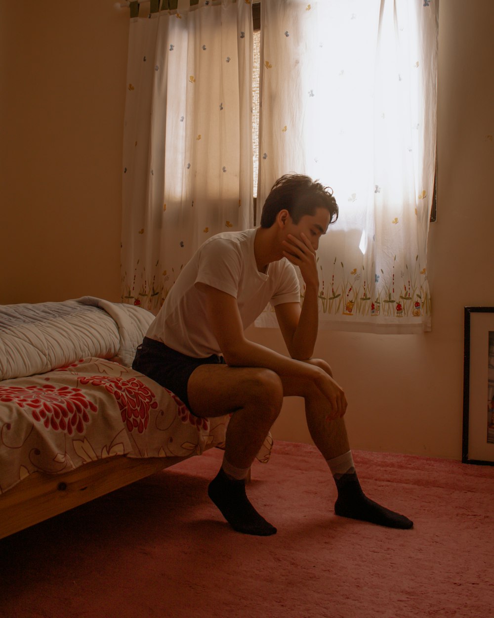 man in white crew neck t-shirt sitting on bed