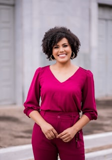 woman in red long sleeve shirt standing near white wall during daytime