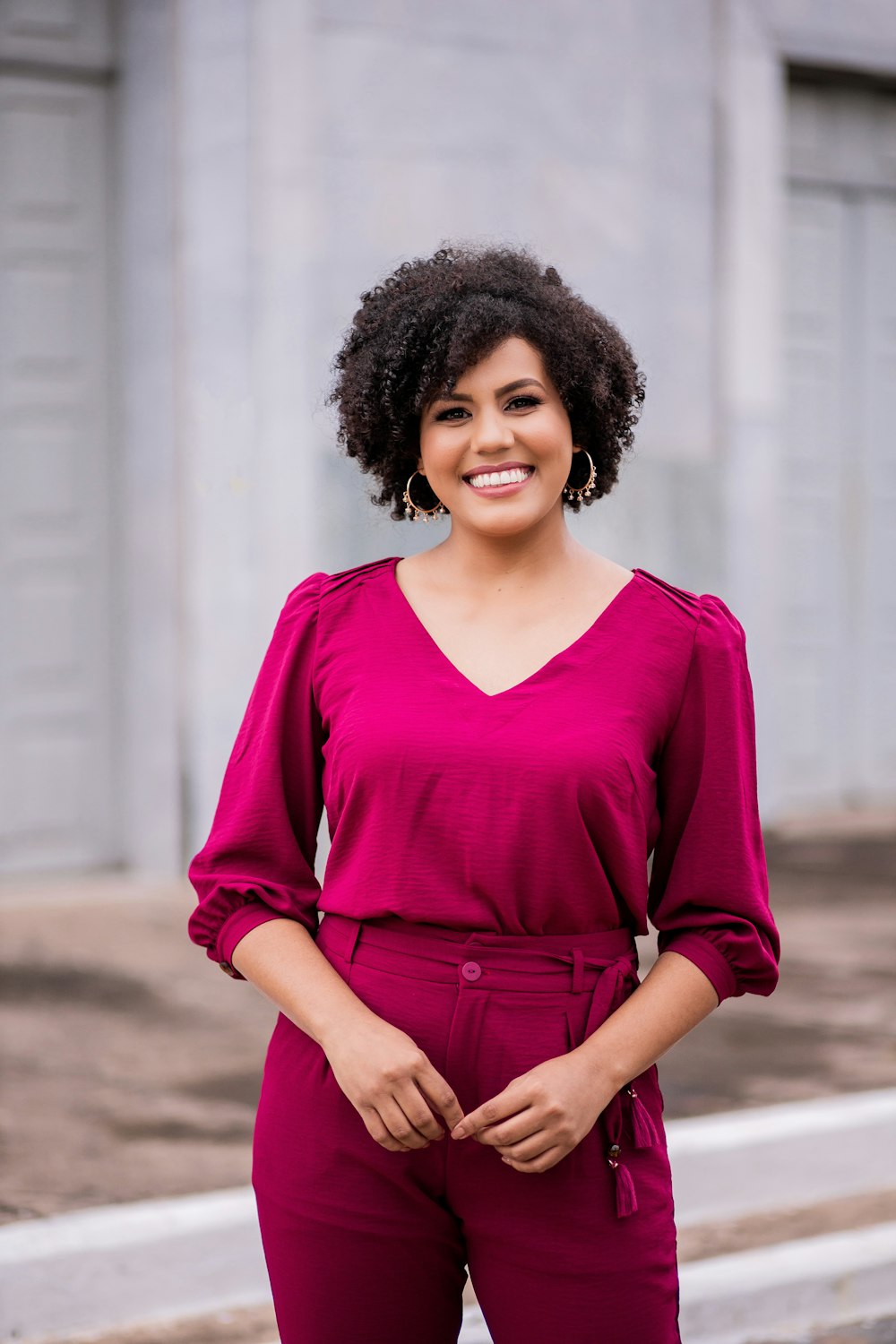 woman in red long sleeve shirt standing near white wall during daytime